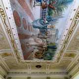 E qui, alzando lo sguardo, restiamo incantati dalla vista del soffitto interamente decorato con teloni dipinti

